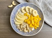 Frühstücksbowl mit Apfel, Mango, Banane und Cashewkernen