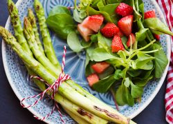 Grüner Spargel mit Salat und Erdbeeren