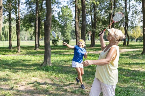 Federball im freien - zwei ältere Damen spielen Federball