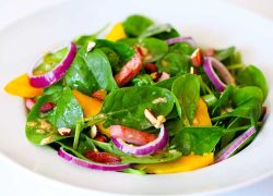 Bunter Salat mit Spinat, Mandeln, Mango und Dressing